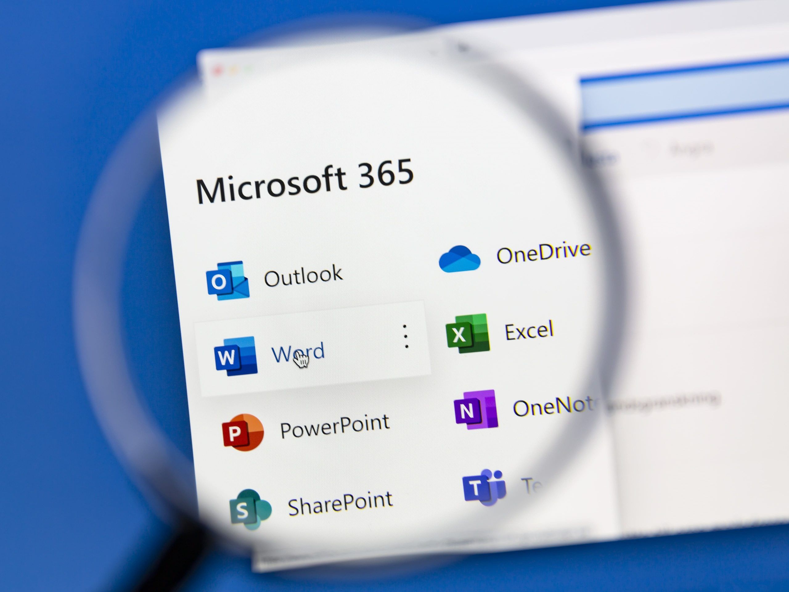 Das Bild zeigt die Microsoft 356 App Icons auf einem Desktop geöffnet unter einer Lupe.
