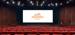 Auf dem Bild ist Hermès Logo auf eine Kinoleinwand projiziert zu sehen.