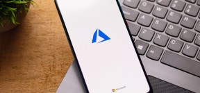 Auf dem Bild ist ein Handy, weches auf einem geöffnetem Laptop liegt und microsoft geöffnet hat, zu sehen.